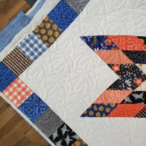 Close up of e2e quilting on sawtooth baby quilt